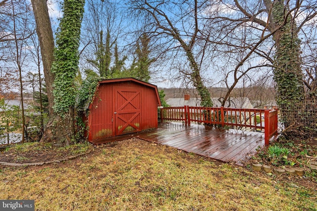 wooden deck featuring a shed and an outdoor structure