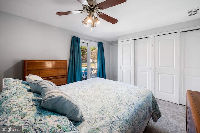 carpeted bedroom with ceiling fan, visible vents, and multiple closets