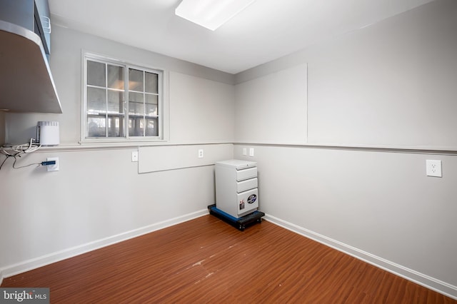 empty room with baseboards and wood finished floors