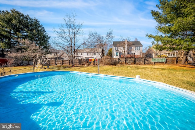 view of pool with a lawn and fence