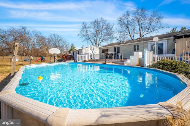 view of swimming pool with a fenced in pool, a deck, and fence