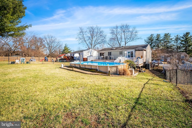 view of yard featuring central air condition unit, a fenced backyard, a fenced in pool, and a wooden deck