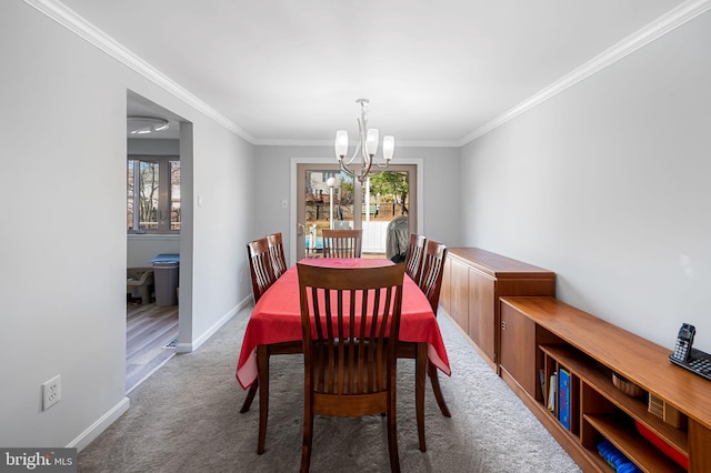 dining room featuring baseboards, carpet, a chandelier, and crown molding