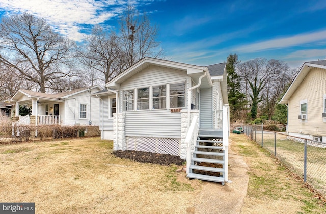 view of front of house featuring a front yard, fence, and cooling unit