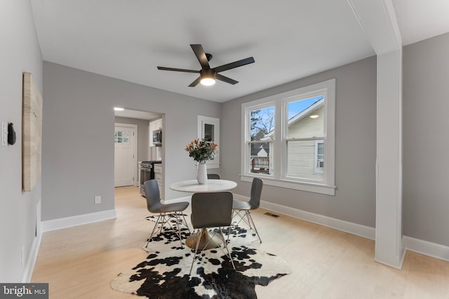 dining room with visible vents, light wood-style flooring, and baseboards