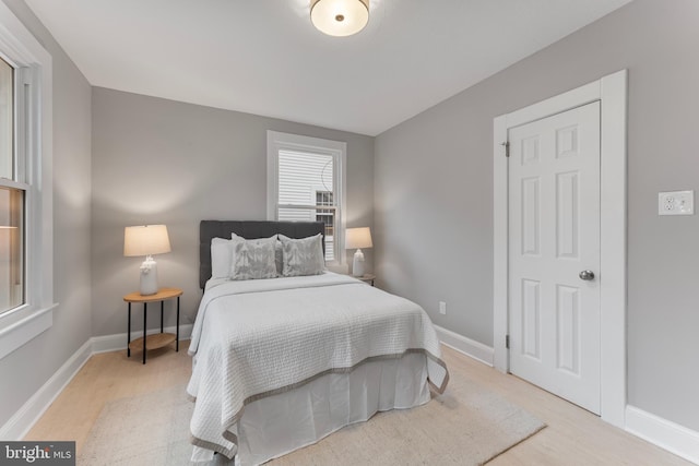 bedroom featuring light wood-style floors and baseboards