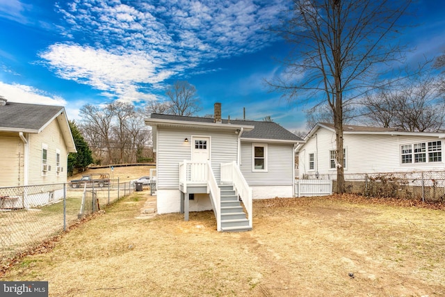 rear view of house with a chimney, fence, and roof with shingles