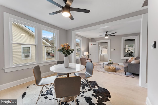 dining space with visible vents, plenty of natural light, baseboards, and wood finished floors