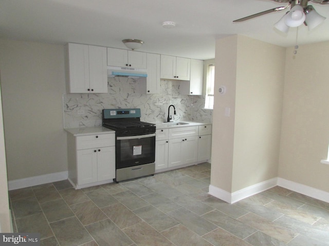 kitchen with under cabinet range hood, light countertops, a sink, and gas stove