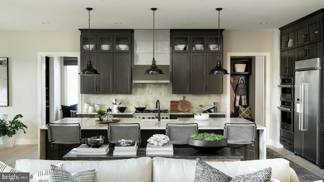 kitchen with a sink, glass insert cabinets, tasteful backsplash, and high end refrigerator