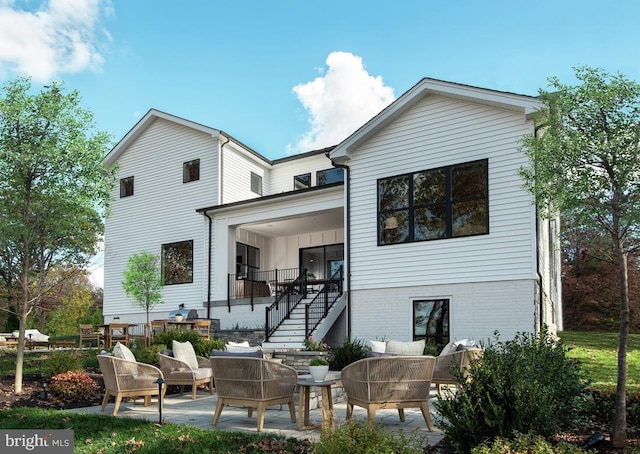 back of property featuring an outdoor living space, stairway, a patio, and brick siding