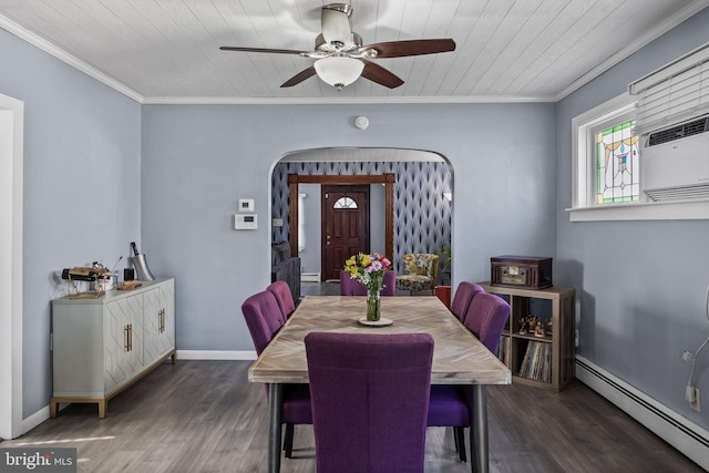 dining space with arched walkways, crown molding, a baseboard heating unit, and wood finished floors