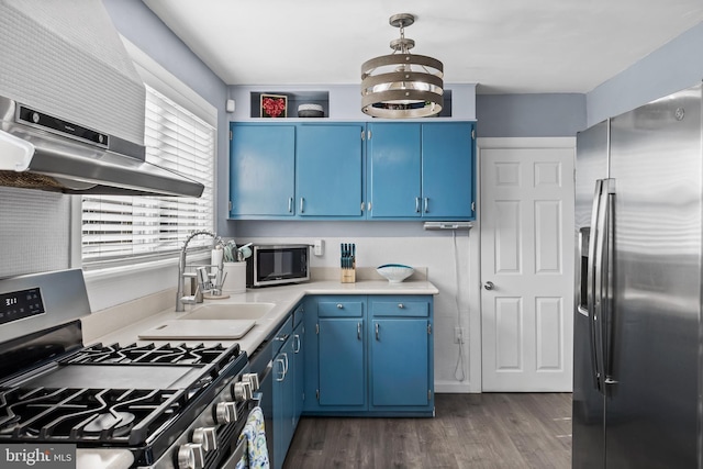 kitchen with blue cabinetry, appliances with stainless steel finishes, light countertops, and under cabinet range hood