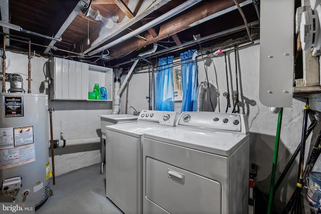 clothes washing area featuring water heater, laundry area, and separate washer and dryer