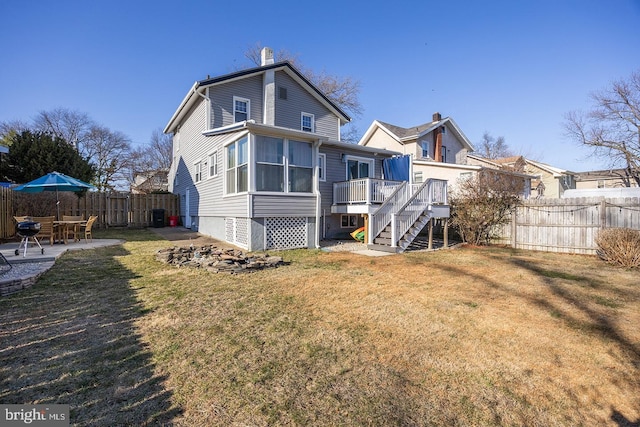 rear view of house with stairs, a patio, a lawn, and a fenced backyard