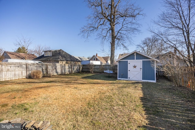 view of yard featuring an outbuilding, a trampoline, a fenced backyard, and a shed