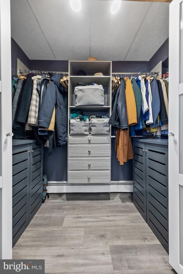 walk in closet with wood finished floors