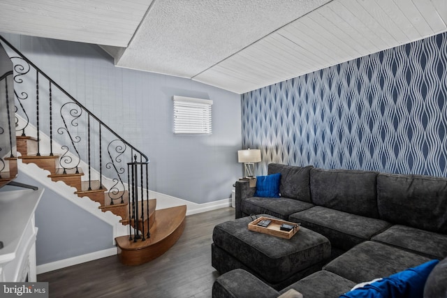 living area featuring baseboards, lofted ceiling, wood finished floors, and stairs