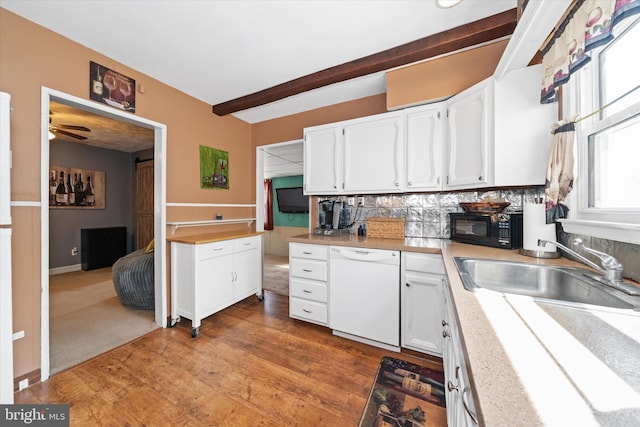 kitchen featuring beam ceiling, light wood-style floors, white cabinets, black microwave, and dishwasher