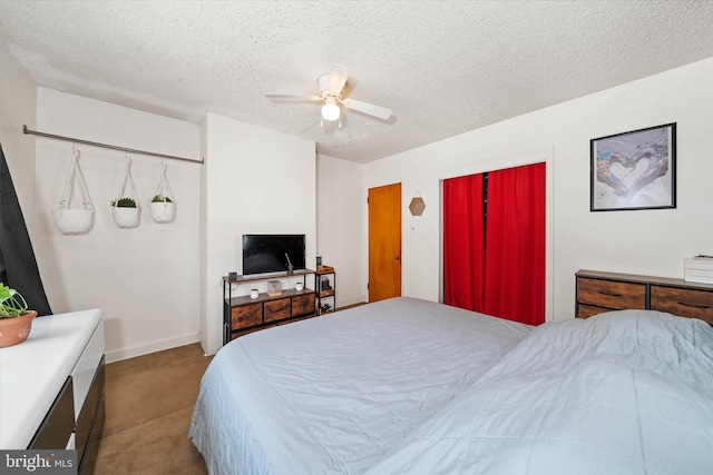 bedroom featuring a textured ceiling, ceiling fan, and carpet floors