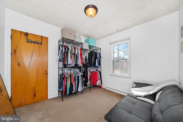 walk in closet with a baseboard radiator and carpet flooring