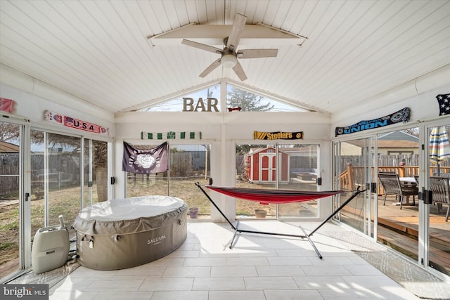 sunroom featuring plenty of natural light, vaulted ceiling with beams, and ceiling fan