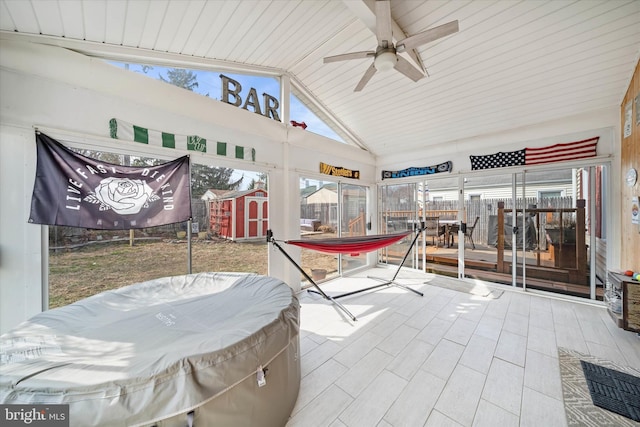 view of patio with an outbuilding, a ceiling fan, fence, a shed, and outdoor dining area