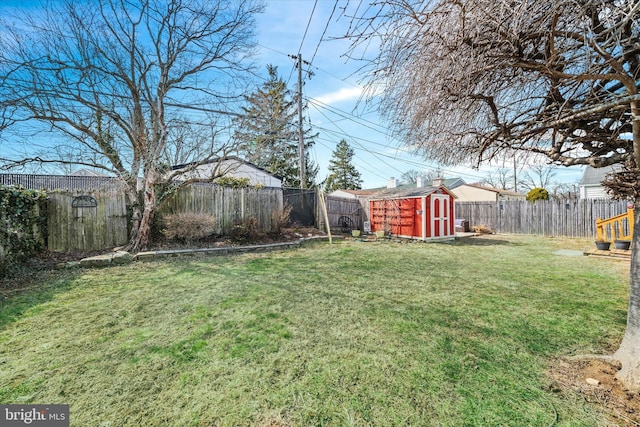 view of yard featuring an outbuilding, a storage shed, and a fenced backyard