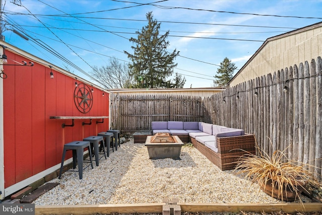 view of patio featuring an outbuilding, an outdoor living space with a fire pit, and a fenced backyard