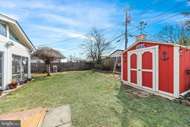 view of yard with an outbuilding, a storage unit, and a fenced backyard