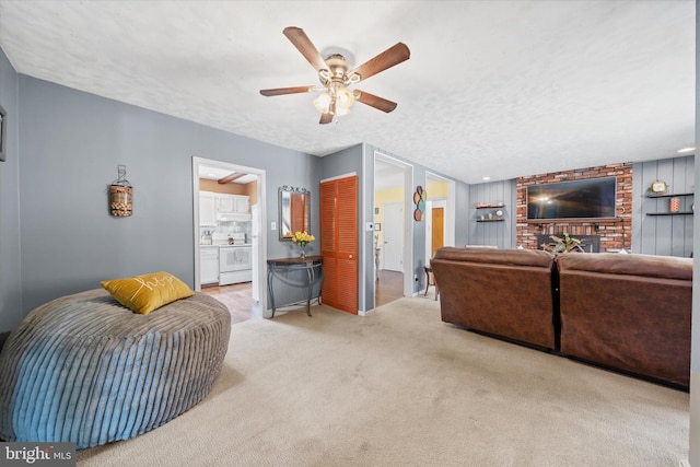 carpeted living area featuring a textured ceiling and a ceiling fan