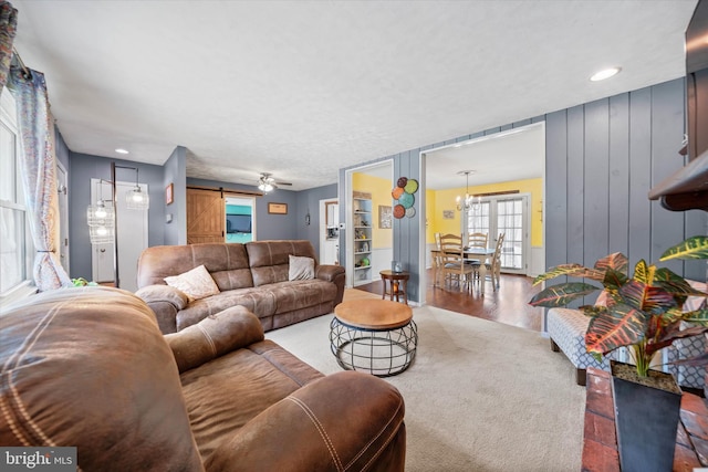 living area with recessed lighting, a barn door, and wood finished floors