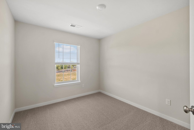 spare room featuring baseboards, visible vents, and carpet flooring