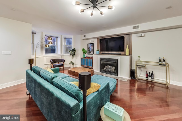 living room featuring baseboards, a fireplace, visible vents, and wood finished floors