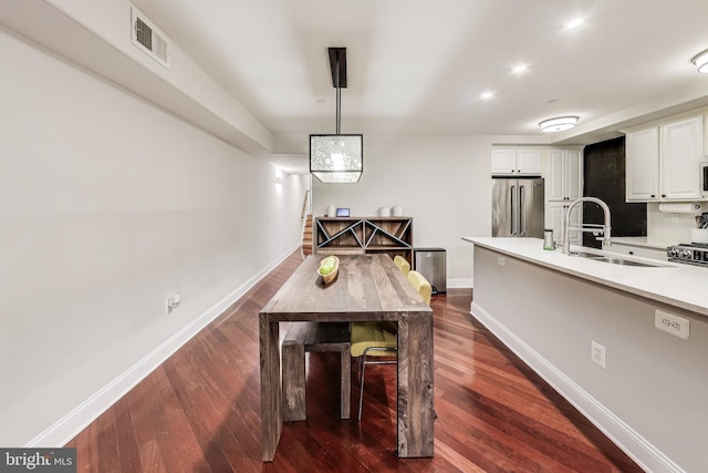 dining room with dark wood-style floors, visible vents, and baseboards