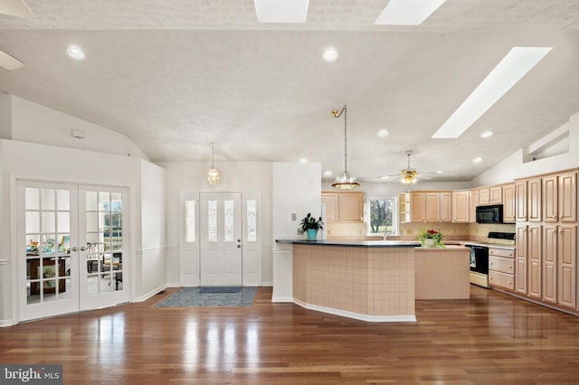 kitchen with wood finished floors, light brown cabinets, vaulted ceiling with skylight, range with electric cooktop, and black microwave