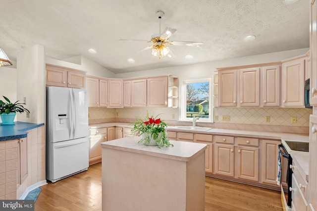 kitchen featuring light brown cabinets, white fridge with ice dispenser, and electric range oven