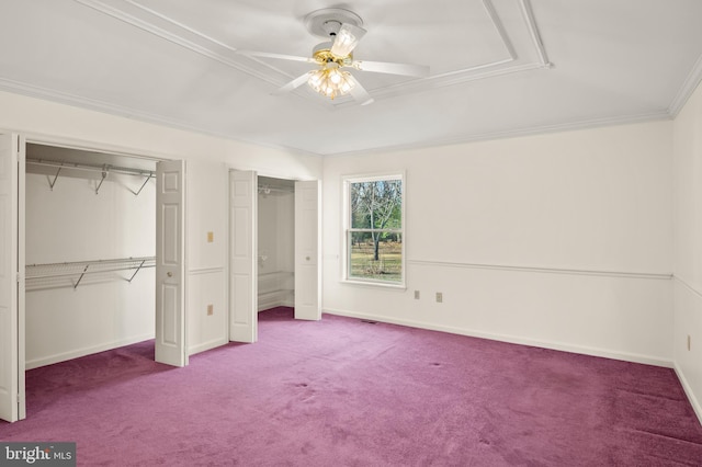 unfurnished bedroom featuring baseboards, ceiling fan, ornamental molding, carpet flooring, and two closets