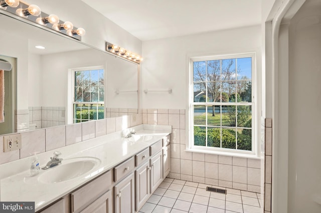 full bath with tile patterned flooring, tile walls, visible vents, and a sink