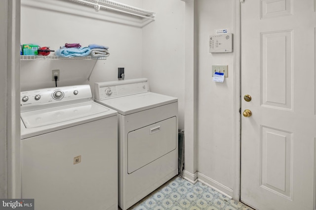 clothes washing area featuring washing machine and clothes dryer, laundry area, and baseboards