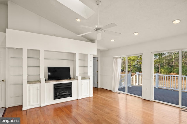 unfurnished living room with recessed lighting, lofted ceiling with skylight, light wood-style floors, and ceiling fan