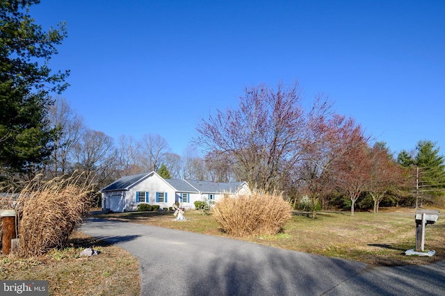 single story home featuring aphalt driveway and a front lawn