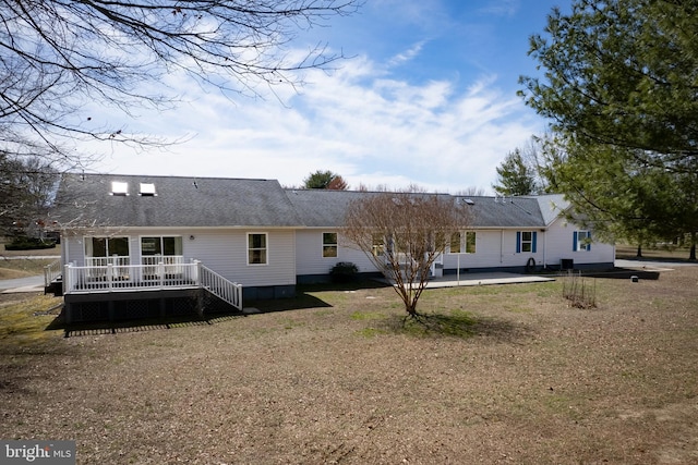 back of house with a wooden deck and a patio area