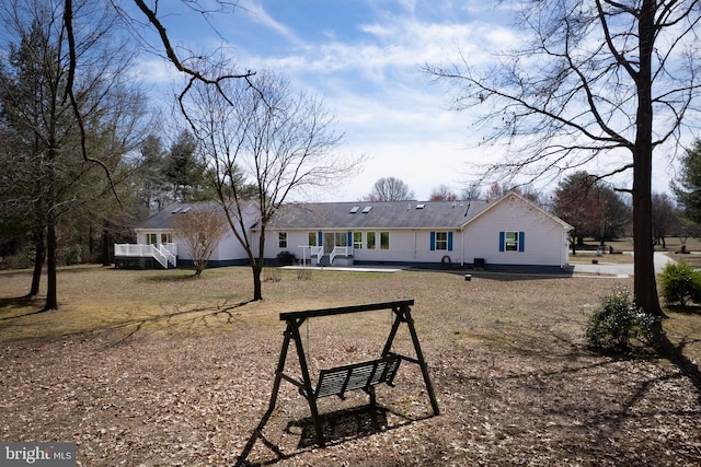 back of house featuring a deck and a garage