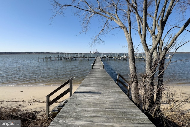 view of dock with a view of the beach and a water view