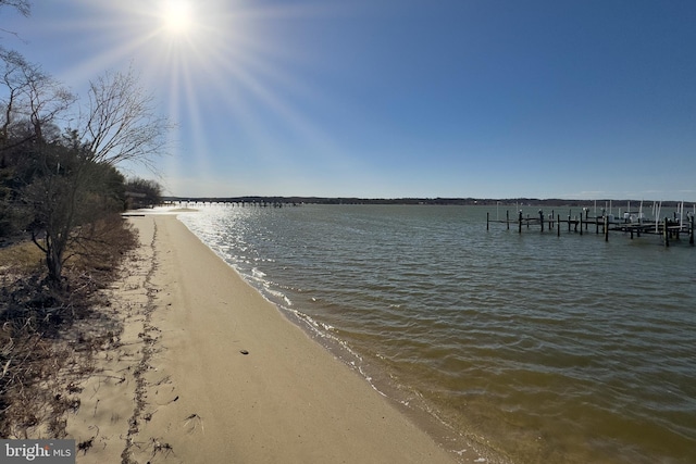 property view of water with a beach view and a dock