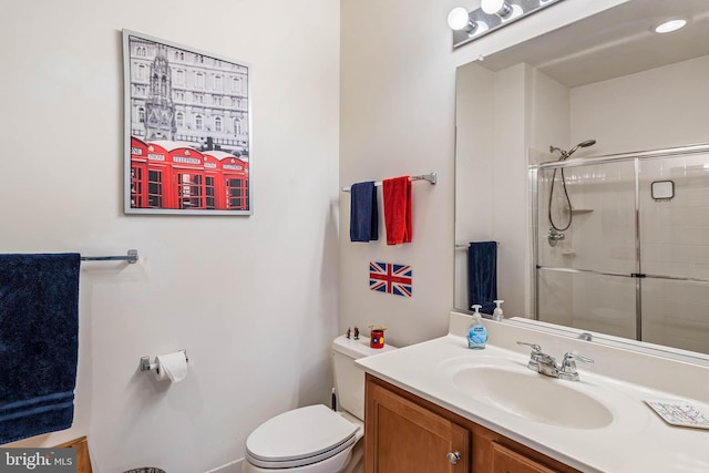 bathroom featuring a tile shower, toilet, and vanity