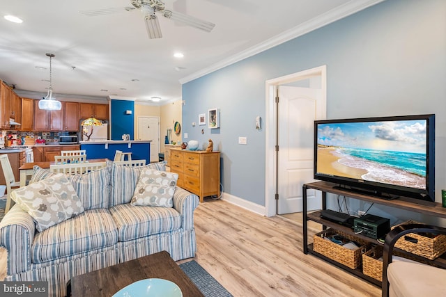 living room with crown molding, baseboards, recessed lighting, light wood-style floors, and a ceiling fan