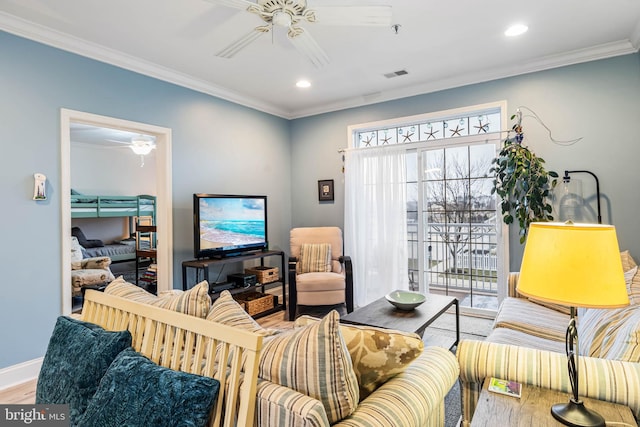 living room featuring visible vents, ornamental molding, ceiling fan, and wood finished floors