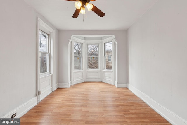 unfurnished room featuring light wood-style flooring, baseboards, and ceiling fan